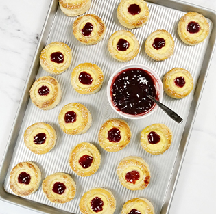 cookies with raspberry filling on a extra-large sheet pan